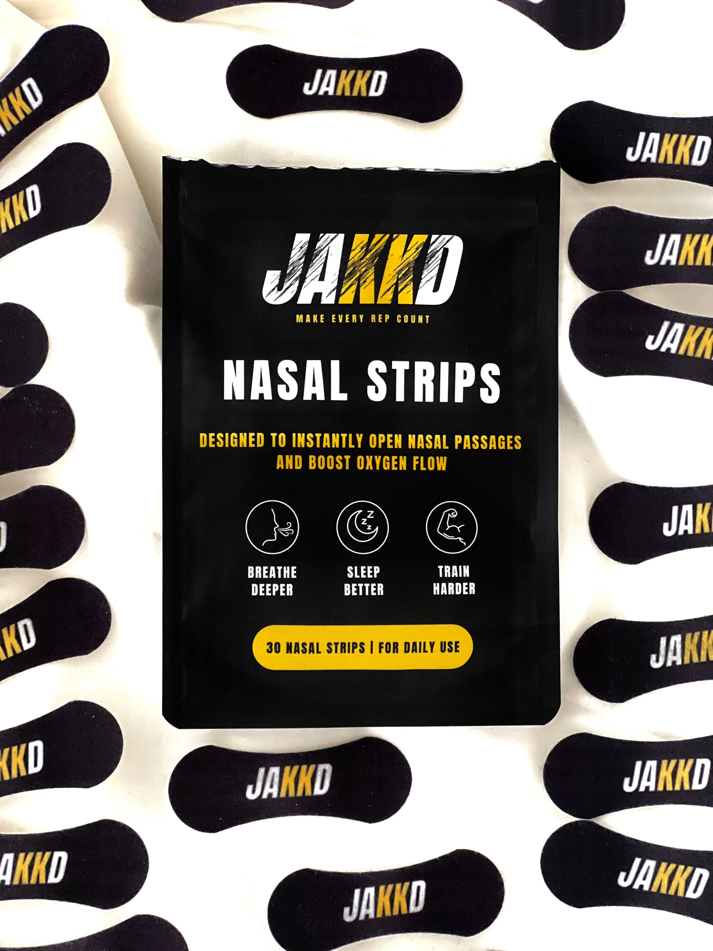 A JAKKD nasal strips pack surrounded by the 30 single use strips it contains